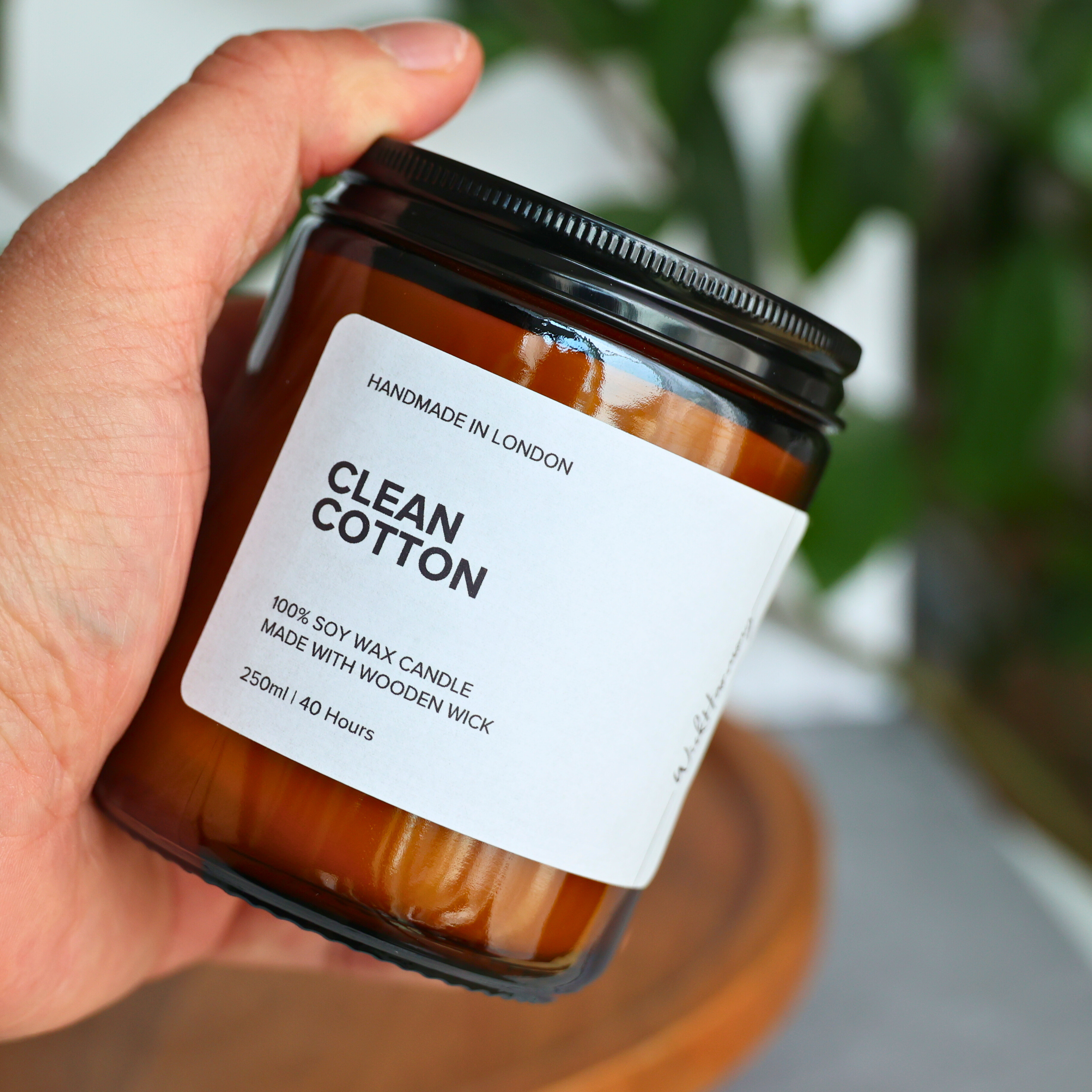 candle-250ml-amber-jar-in-hand.jpg	A hand holding the 250ml amber jar 'Clean Cotton' soy wax candle to show its size and scale.