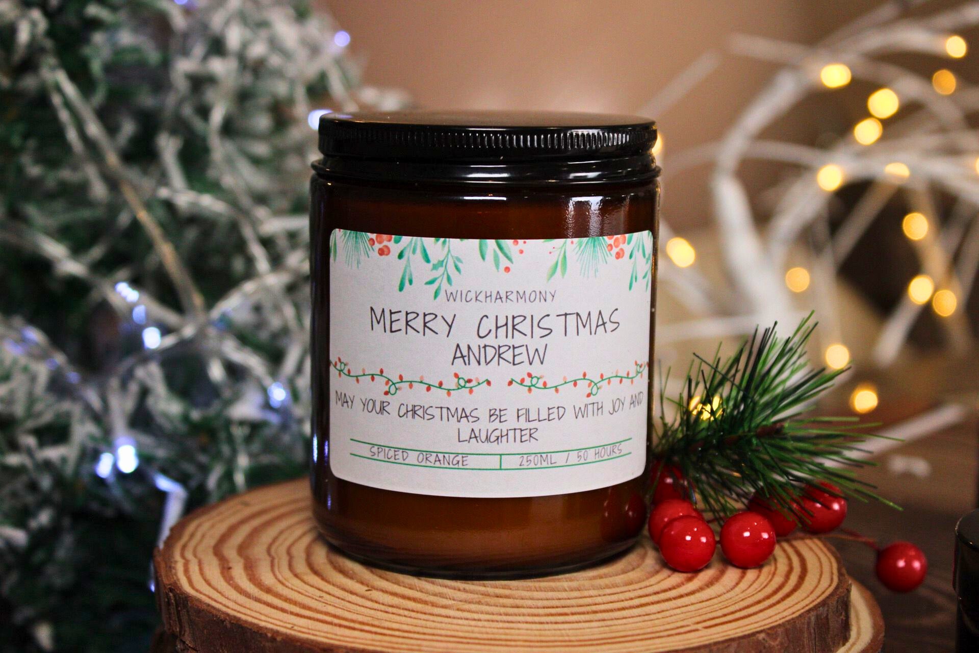 An extra large 250ml Spiced Orange Christmas candle with a personalised label sitting on a wooden coaster.