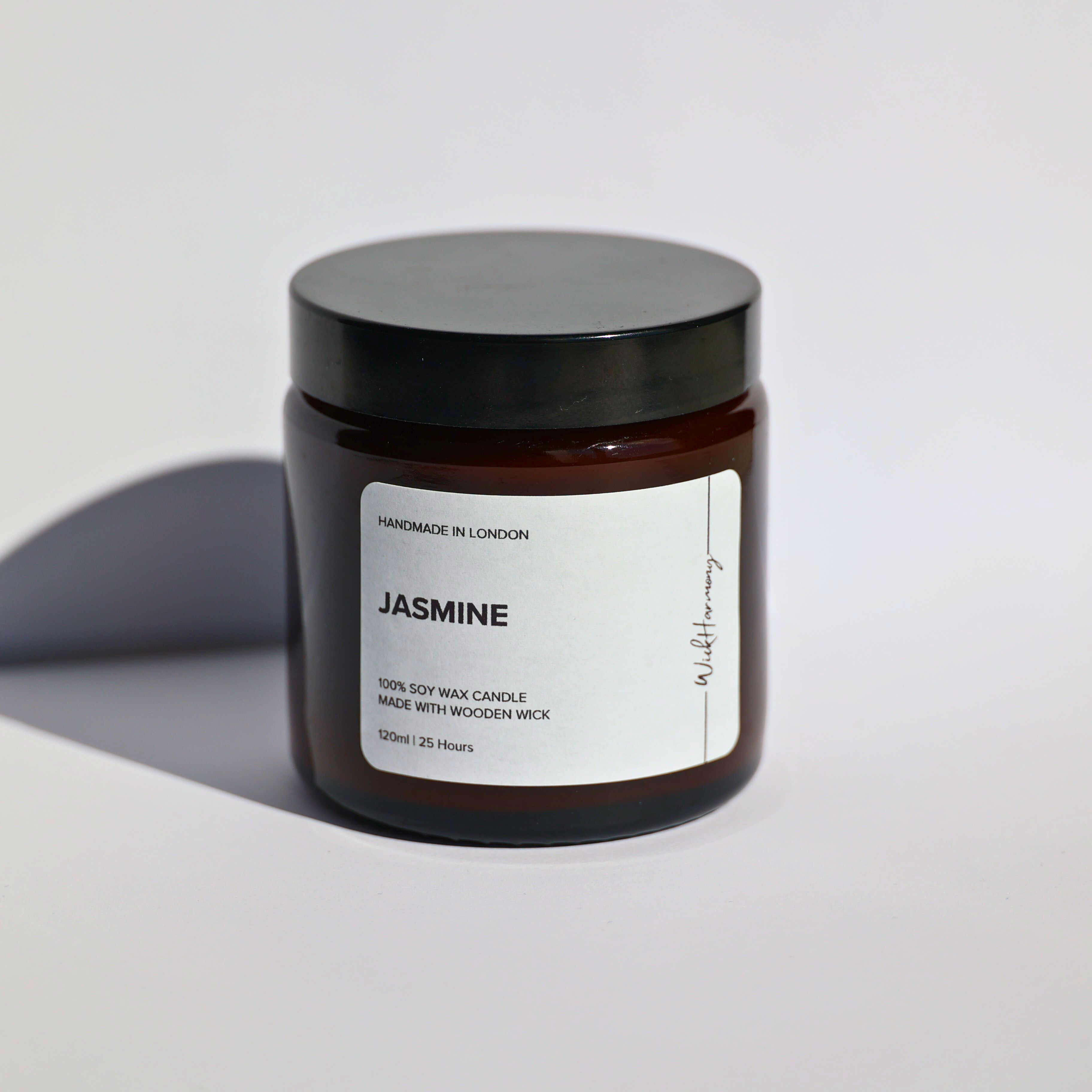 A 120ml amber jar 'Jasmine' soy wax candle by WickHarmony, shown in a studio product shot against a plain white background.
