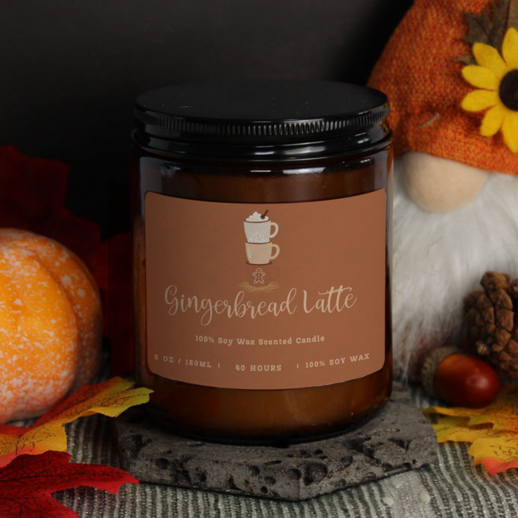 The 180ml 'Cosy Sketchbook' soy candle by WickHarmony, featuring the Gingerbread Latte design and styled with an autumn gnome