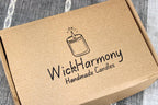 A recyclable kraft shipping box with the WickHarmony Handmade Candles logo stamped on top