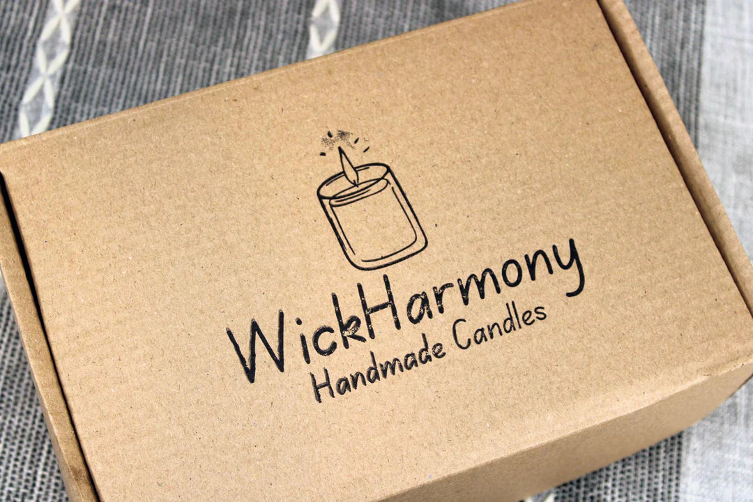 A recyclable kraft shipping box with the WickHarmony Handmade Candles logo stamped on top