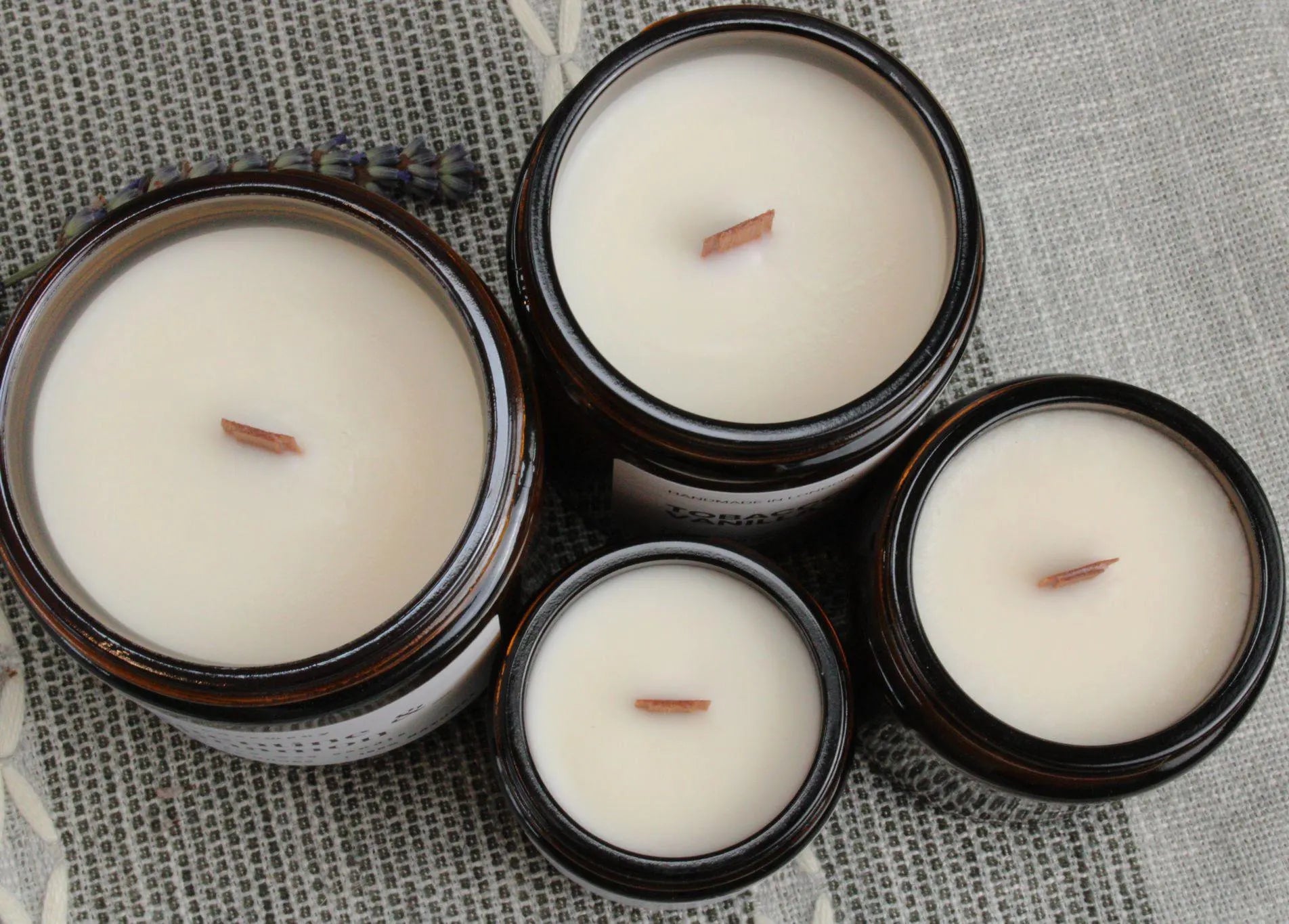 Top-down view of four WickHarmony soy wax candles in amber jars, showing the natural wooden wicks