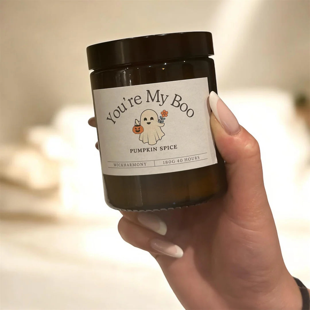 A person holding the 180ml 'You're My Boo' candle to show the cute ghost label design
